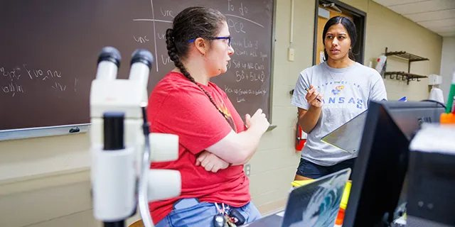University of Kansas community health degree students working with faculty in a lab