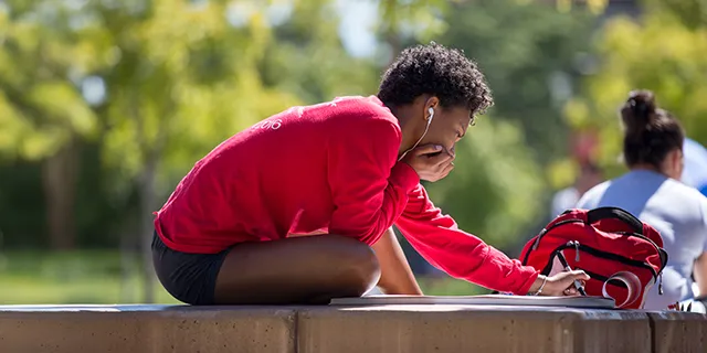 Master of counseling psychology student reviewing therapy techniques on campus
