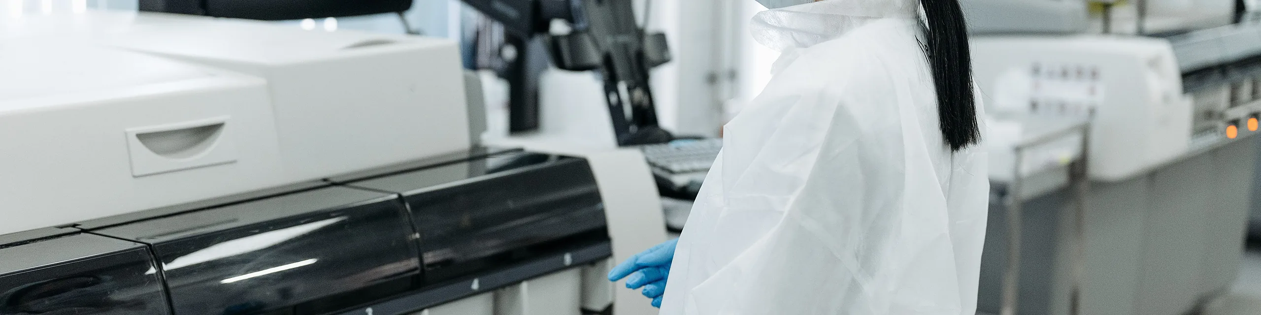 A KU diagnostic science degree student uses automated laboratory equipment to analyze clinical samples in a healthcare laboratory setting.