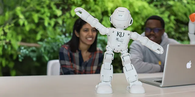 Doctorate of electrical engineering students in KU testing RF circuits with robots in an electrical engineering research lab