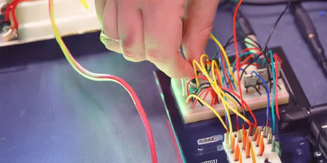 Master of electrical engineering student at KU testing power circuits in an electrical engineering lab