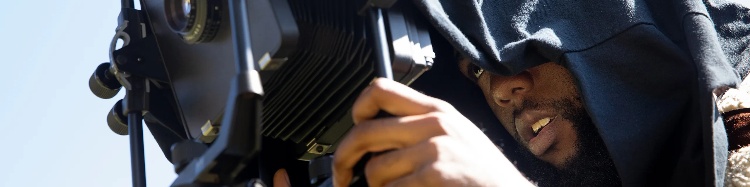 A KU student uses professional camera equipment during a media production project.