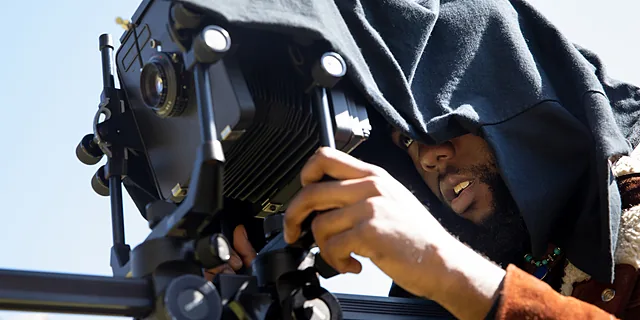 A KU student uses professional camera equipment during a media production project.
