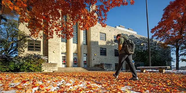 Doctor of geography student at KU overlaying walking to a research lab to review satellite data on urban maps