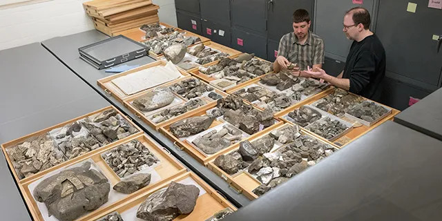 Masters of geology student in KU examining rock samples in a geology lab