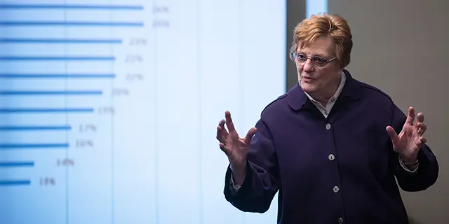 Master of health services administration students analyzing healthcare data dashboards in a university of Kansas administration classroom