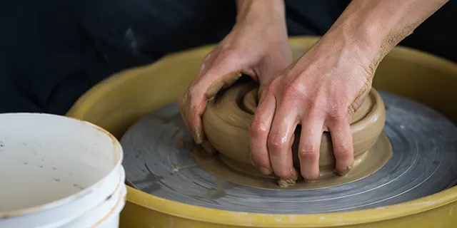 History of art doctorate students working with clay in art studio