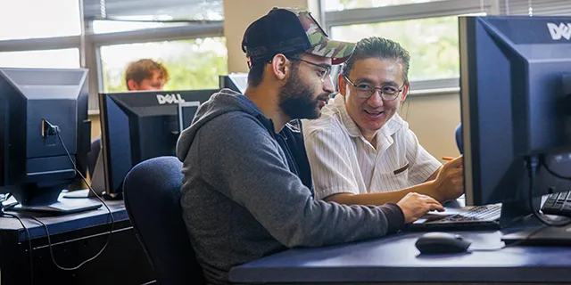 University of Kansas information systems degree students working with faculty in information systems lab
