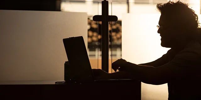 Master of information technology student at KU configuring cloud servers in an information technology lab