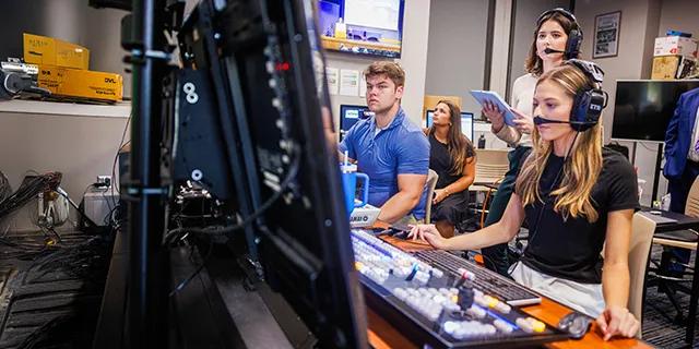 University of Kansas jounralism degree students reporting news in journalism studio