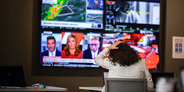 Doctor of Journalism and Mass Communication student at KU reviewing news broadcasts from around the world