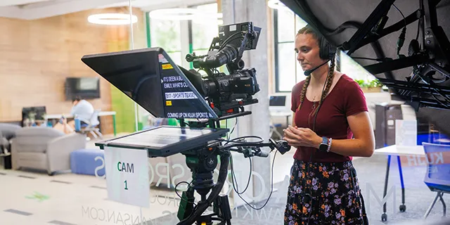 Journalism and mass communication masters degree students in KU editing a news broadcast in a journalism production studio
