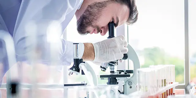 Student peering through a microscope