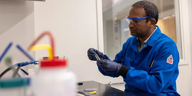 Doctor of medicinal chemistry student at KU synthesizing compounds in a medicinal chemistry research lab