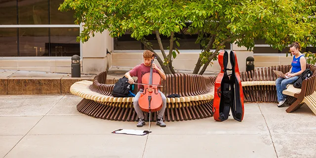 University of Kansas music student practicing the cello on campus