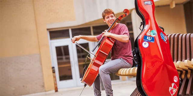 Graduate music student practicing the cello on campus