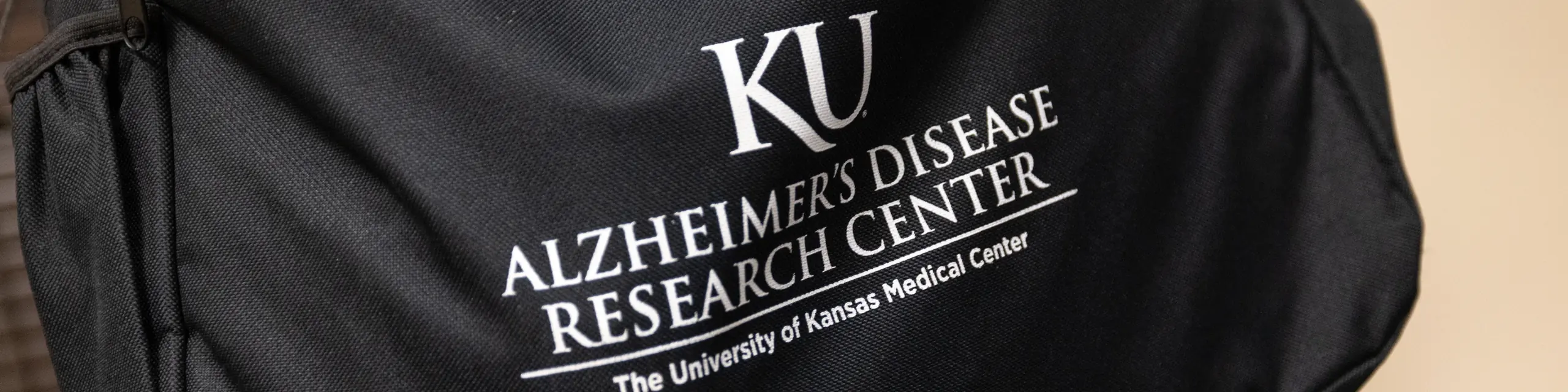 A shoulder bag branded with the KU Alzheimer's Disease Research Center logo at the University of Kansas Medical Center.