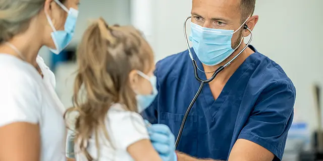 Doctor of nursing practice student at KU examining a child patient