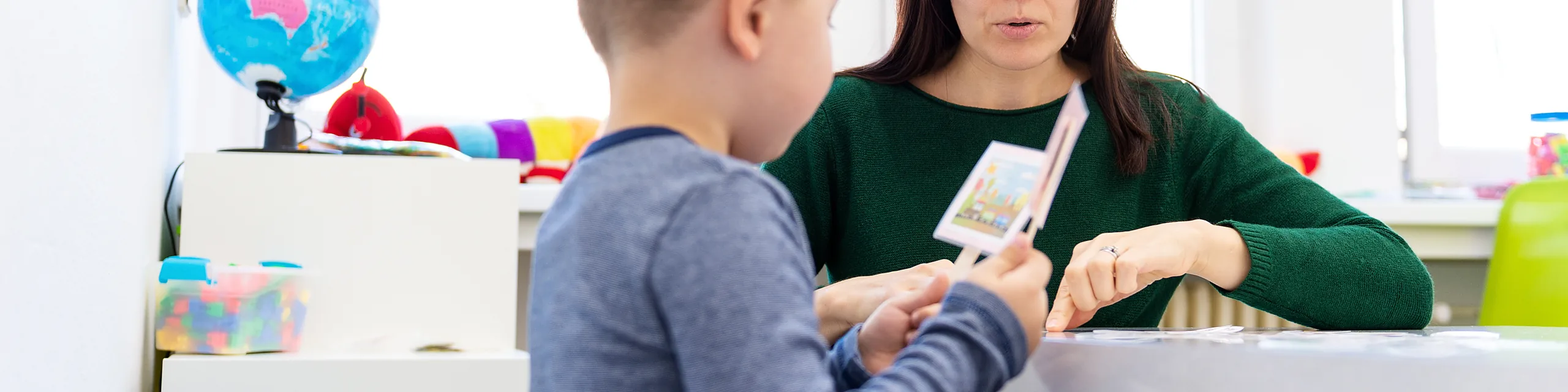 A KU doctor of speech language pathology student conducts a language and communication session with a child in a clinical education setting.