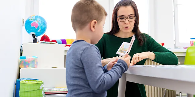 A KU doctor of speech language pathology student conducts a language and communication session with a child in a clinical education setting.